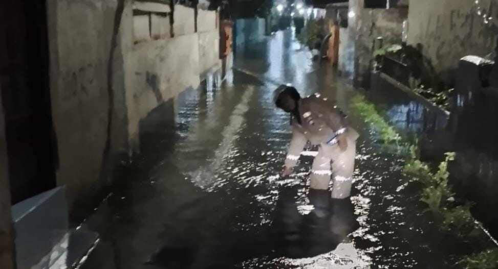 Antisipasi Dampak Hujan, Bhabinkamtibmas Kalibaru Pantau Genangan Air di Jalan Rawa Bakti